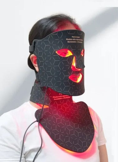 Photon LED light-therapy rejuvenation mask in black with glowing red lights, worn on face